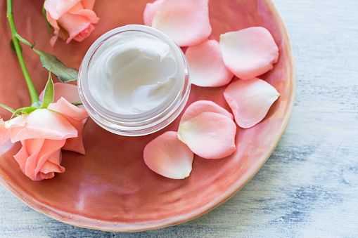 Cosmetic cream on antic plate with rose flowers