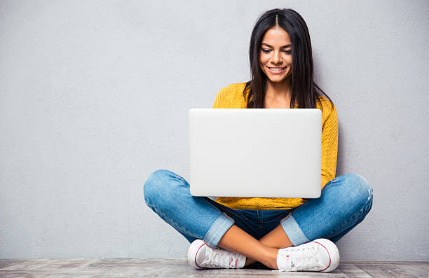 frau sitzt auf dem boden und mit laptop - floor sitting stock-fotos und bilder