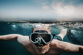 Man scuba diving underwater in sea with mask