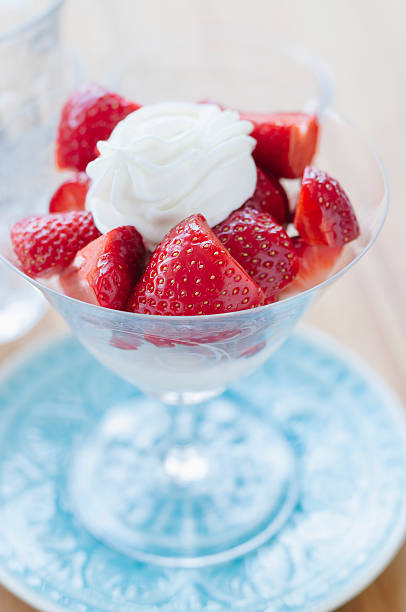 istock Strawberries with cream in goblet on blue plate 481968490