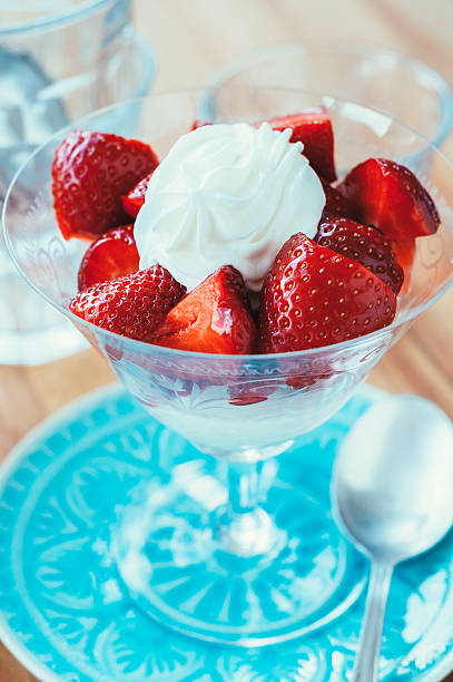 istock Strawberries with cream in goblet on blue plate 481968992
