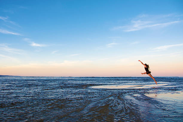 istock Girl leaping across water 481969002