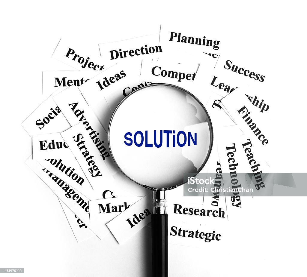 Solution concept Solution magnifying glass with some business concept word paper around it. 2015 Stock Photo