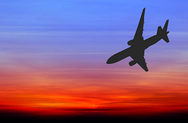 istock Silhouetted commercial airplane flying at sunset 481970296