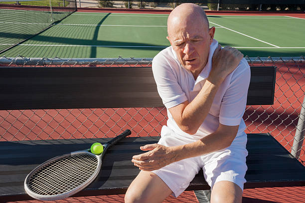 starszy mężczyzna tenisistka bóle siedzi na dziedziniec - tennis active seniors healthy lifestyle senior men zdjęcia i obrazy z banku zdjęć