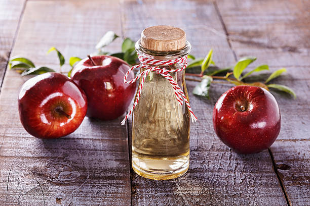 Apple cider vinegar over rustic wooden background stock photo