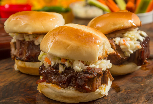 beef brisket sliders smothered in BBQ sauce and topped with cole slaw ready to eat