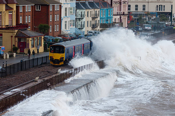 Local train passing Dawlish station during severe storm Dawlish, England - February 3, 2014: Local train passing Dawlish station during severe storm ballast water stock pictures, royalty-free photos & images