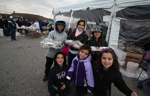 Staten Island - New York - USA - November 4 2012: Red Cross & the national guard conduct relief efforts for victims of Hurricane Sandy at New Dorp high. Young volunteers pose with food trays