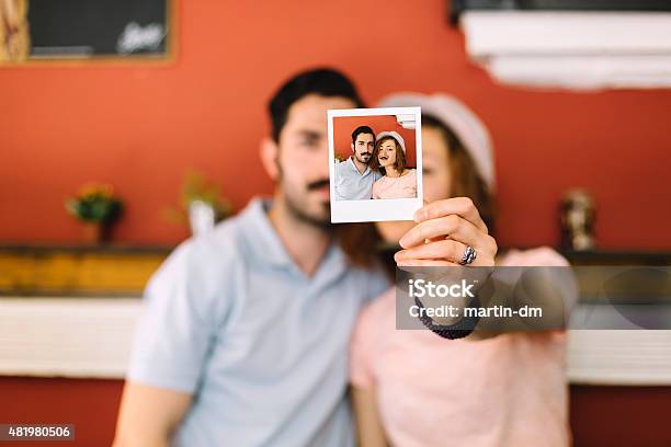 Young Couple Holding Instant Photo Stock Photo - Download Image Now - Friendship, Instant Print Transfer, 20-29 Years