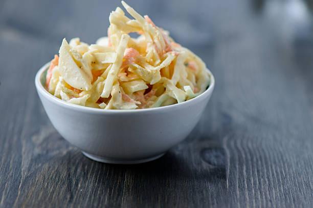 salade de chou dans un bol sur une table en bois - coleslaw photos et images de collection