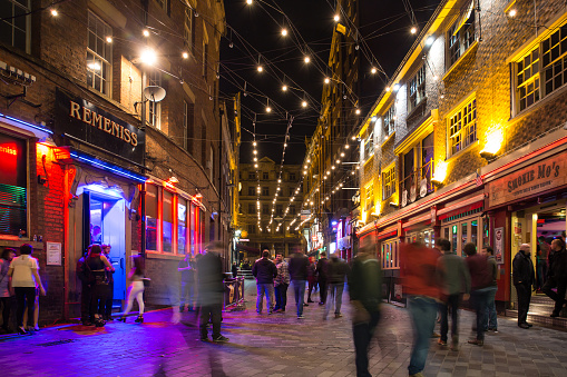 Liverpool, United Kingdom - October 11, 2014:  Night scene alone historic Matthew Street in Liverpool with people visible.  This notable street is famous for it's music scene and is home to the landmark Cavern Club where the Beatles played in their early years. 