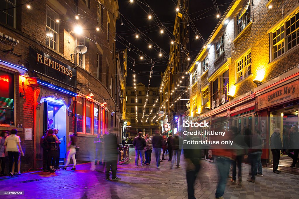 Matthew Street Liverpool Liverpool, United Kingdom - October 11, 2014:  Night scene alone historic Matthew Street in Liverpool with people visible.  This notable street is famous for it's music scene and is home to the landmark Cavern Club where the Beatles played in their early years.  Liverpool - England Stock Photo