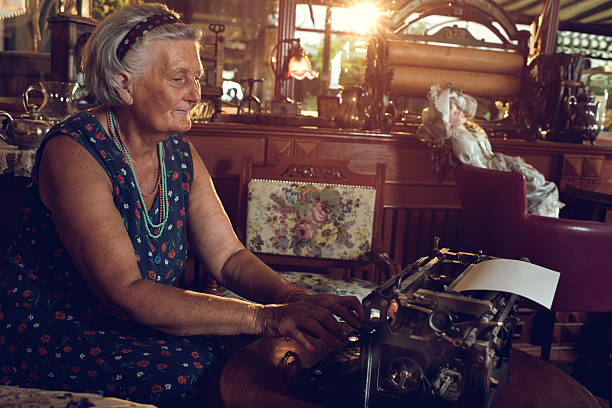 istock Senior woman sitting at home and using typewriter. 481990330
