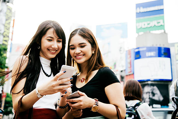 istock Young women using their smart phones, shopping district 481990950