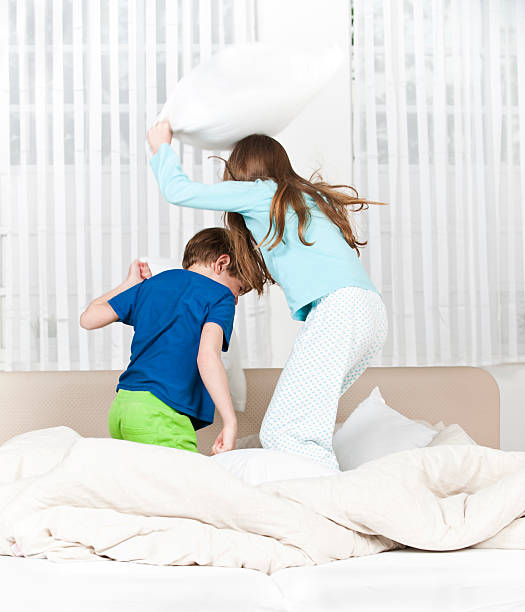 istock Children playfighting on parents' bed 481991884