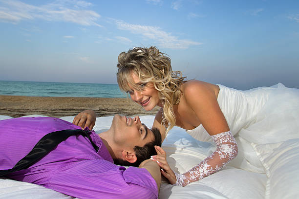 junges paar schlafen im bett - wedding beach groom bride stock-fotos und bilder
