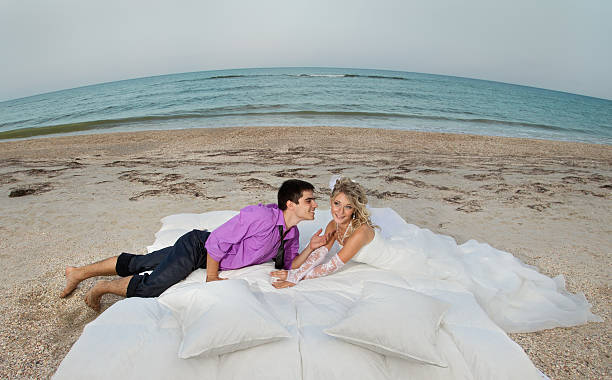 junges paar schlafen im bett - wedding beach groom bride stock-fotos und bilder