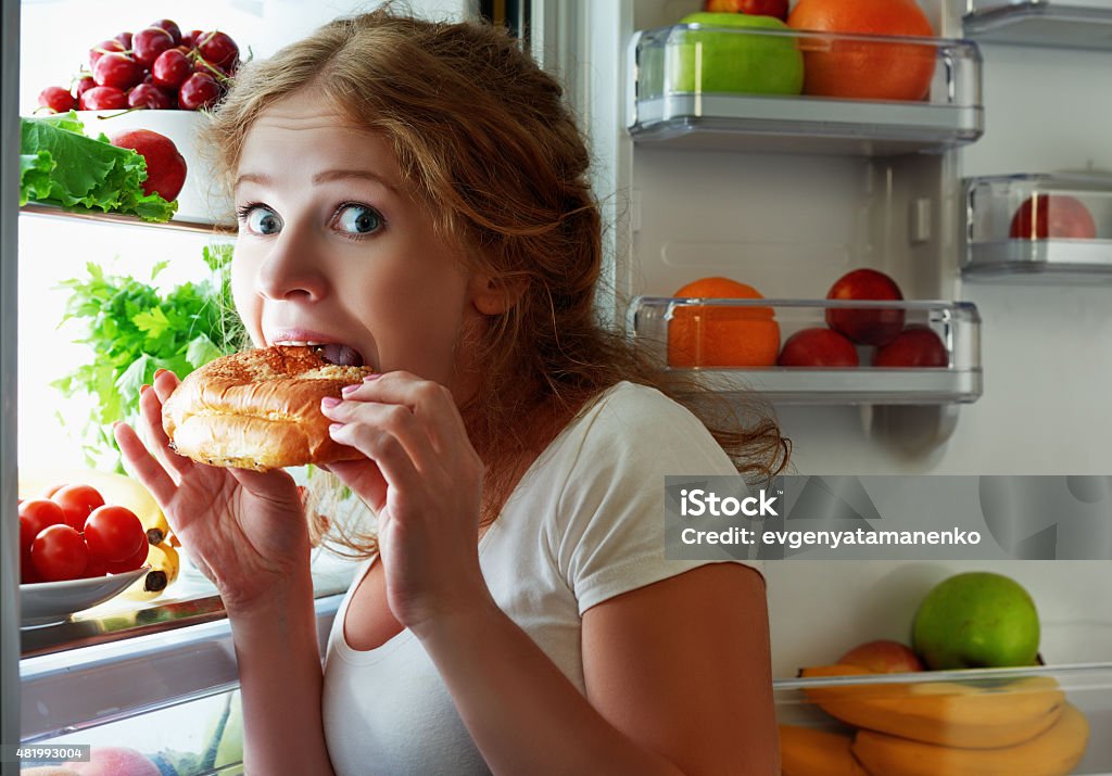 Femme mange nuit étole le réfrigérateur - Photo de Avoir faim libre de droits