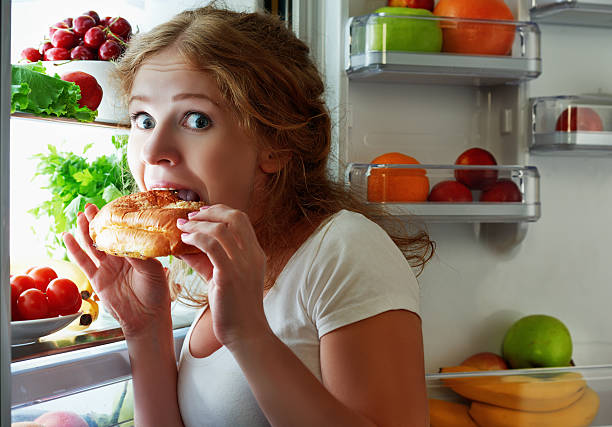 donna mangia notte stola il frigorifero - affamato foto e immagini stock