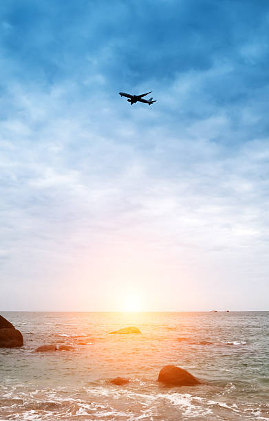 istock airplane fly over sea and sunset 481994774