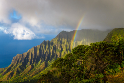 Rainbow over Na Pali Coast at sunset, photographed from Ke'e Beach on the island of Kauai, Hawaii, USA.