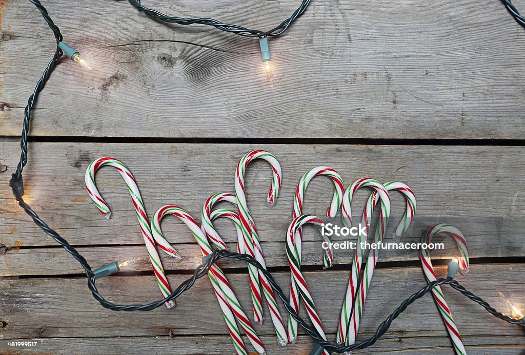 candy canes and lights a rustic festive background of candy canes and Christmas lights Candy Cane Stock Photo