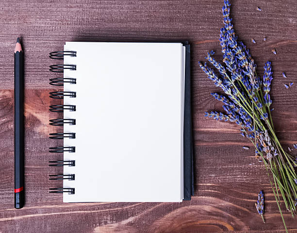 istock Lavender flowers, empty notepad and pensil on wooden table 482000964