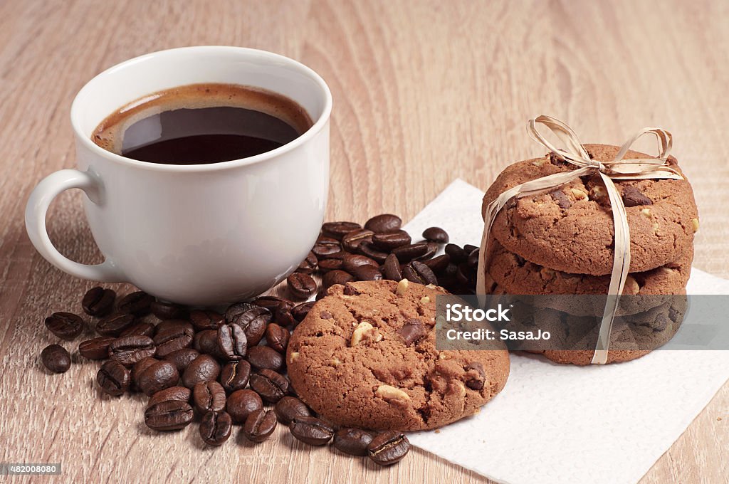 Chocolate cookies and coffee Chocolate cookies with nuts and cup of hot coffee on table 2015 Stock Photo