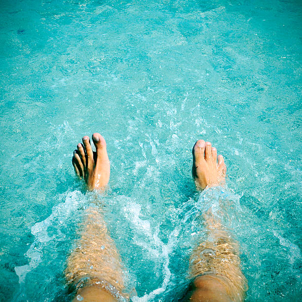 istock young man with his legs into the water 482008156
