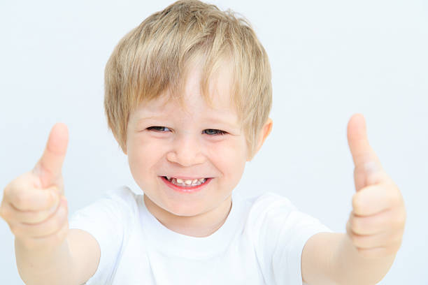 istock happy little boy with thumbs up on white 482010495
