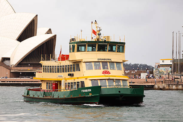 Sydney, Australia, March 25, 2014. A Sydney Ferry, Fishburn, coming in to dock at Circular Quay in Sydney Harbour. Sydney Opera House is in the background.