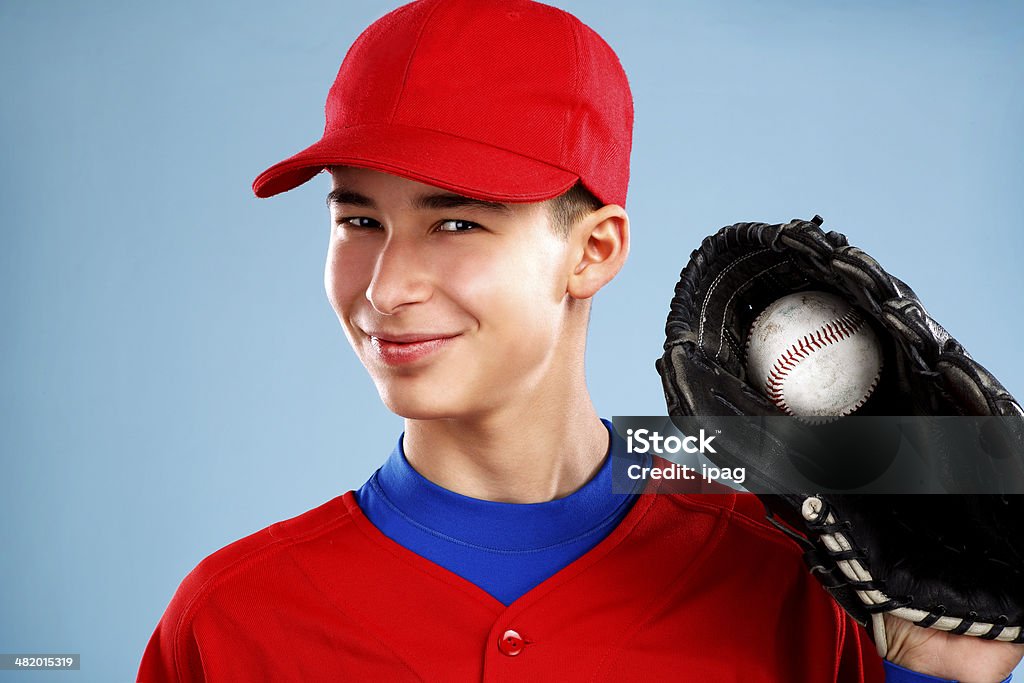 portrait of a  teen baseball player in red uniform portrait of a beautiful teen baseball player in red and white uniform on colorful background Activity Stock Photo