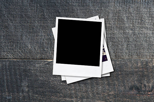 istock Blank photo frames on old wooden background. 482018858