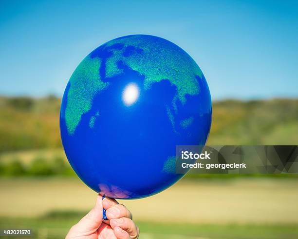 Holding Onto The World Stock Photo - Download Image Now - Balloon, Globe - Navigational Equipment, Planet Earth