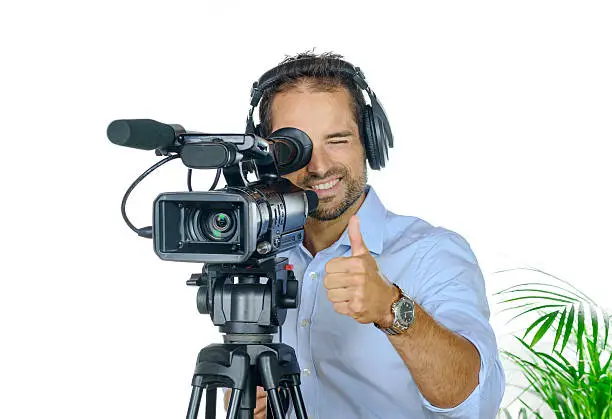 Young man with professional movie camera on white background