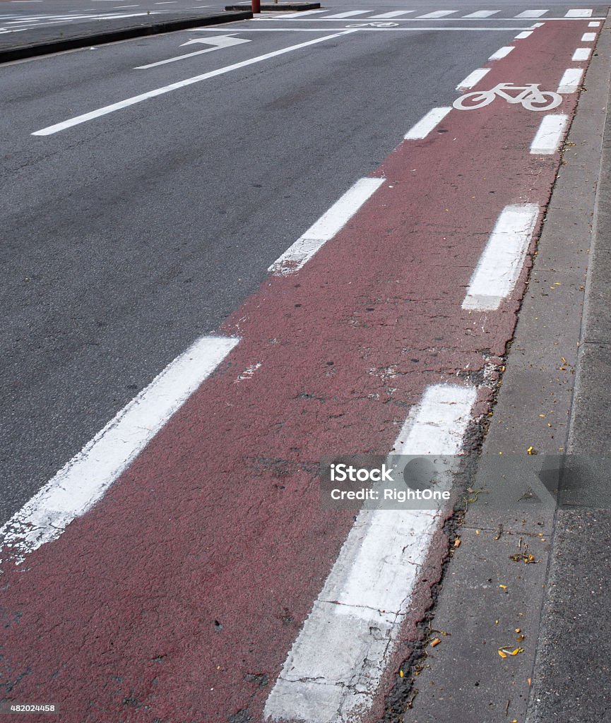 Red European Cycling Path on a Street A red cycling path in an empty street. A common sight in many european cities, where cycling is a common form of transportation. 2015 Stock Photo