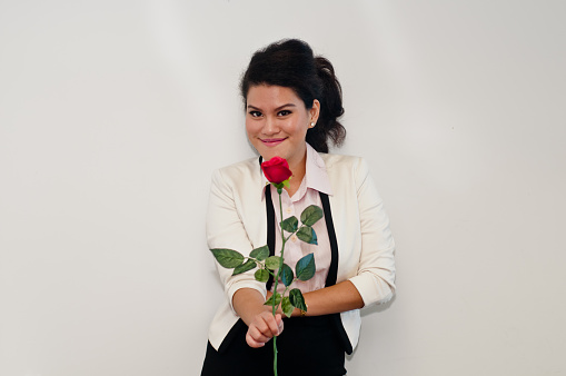 Business woman stand and hold red rose on white background
