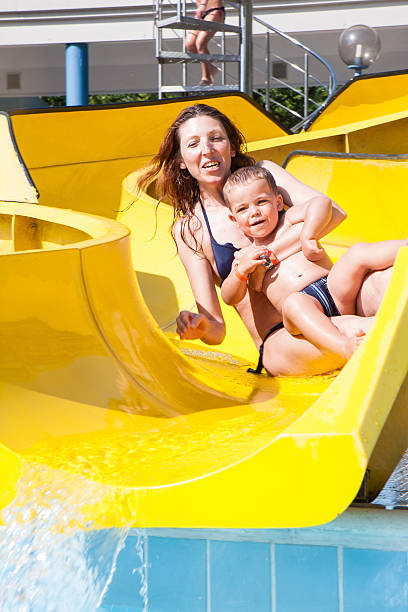 istock child and mom playing with the slide in the pool 482030534