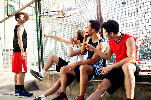 basketball players take a break sitting on a low wall