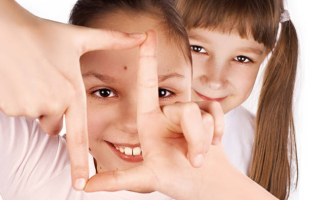 Funny girls, making frame with hands Funny girl, making frame with hands, taking picture with imaginary camera, selective focus, peeping from behind determination focus the bigger picture human hand stock pictures, royalty-free photos & images