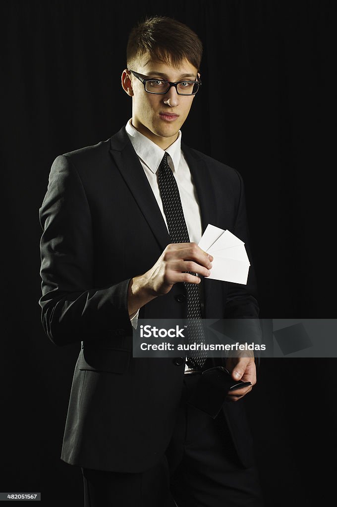 Caucasian man holding few white business cards Caucasian male holding few blank business cards in studio Adult Stock Photo