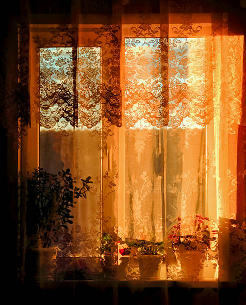 istock window hung a transparent curtain in yellow sunset light 482061082