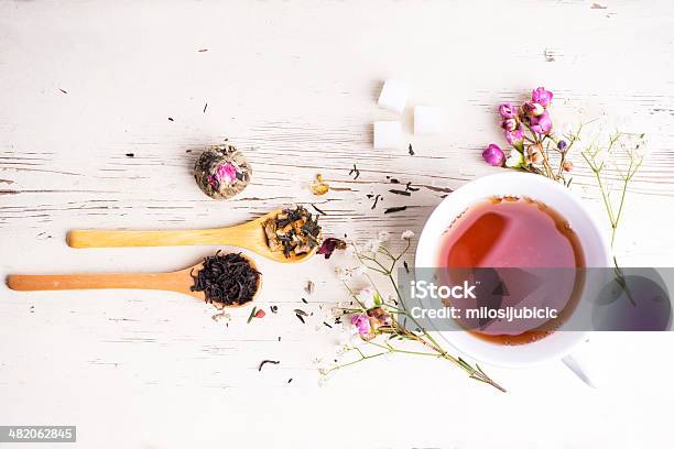 A Teacup Surrounded By Flowers And Tea Leaves Stock Photo - Download Image Now - Breakfast, Dried Tea Leaves, Tea Cup