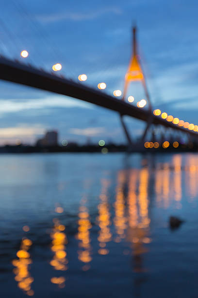 borrosa luces bokeh de puente colgante con reflejo de agua - photography suspension bridge water night fotografías e imágenes de stock