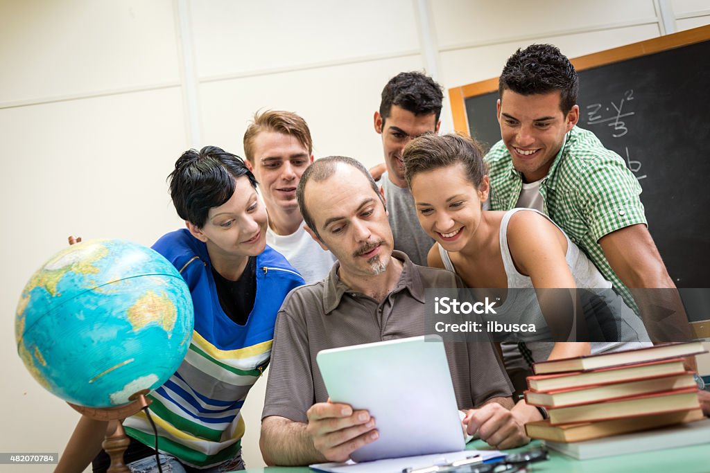 School education scene: students and teacher using tablet 20-29 Years Stock Photo