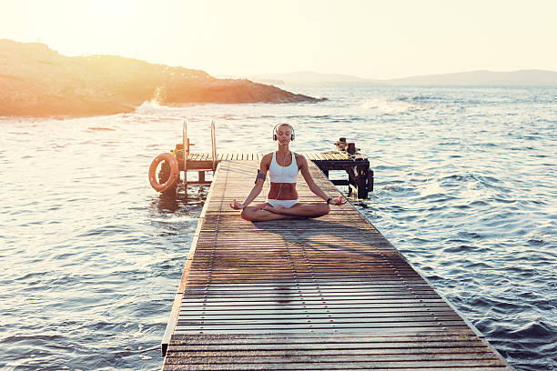 istock Girl at the jetty meditating on sunset 482070978