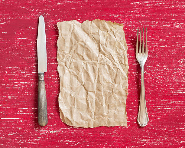 istock Vintage fork and knife with craft paper on red wood 482071004