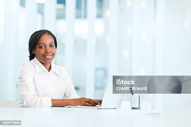 Smiling African American Businesswoman Using Laptop In The Office Stock Photo - Download Image Now