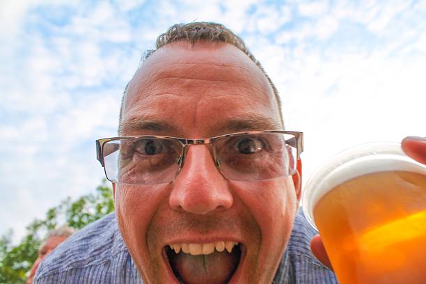 Crazy Boozer A funny man holding a pint of lager festival goer stock pictures, royalty-free photos & images